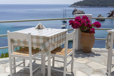 Restaurant tables by the sea outdoor terrace with a few yachts in the background in skopelos, greece