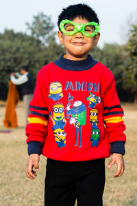 Portrait of boy wearing eye mask standing on field