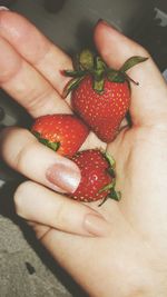 Close-up of hand holding strawberries