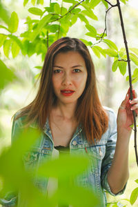 Portrait of young woman holding plant