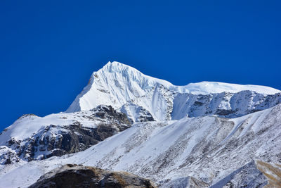 Scenic view of snowcapped mountains against clear blue sky, annapurna