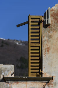 Abandoned building against clear blue sky