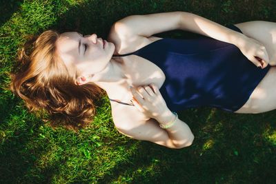 High angle view of woman in bodysuit lying on field