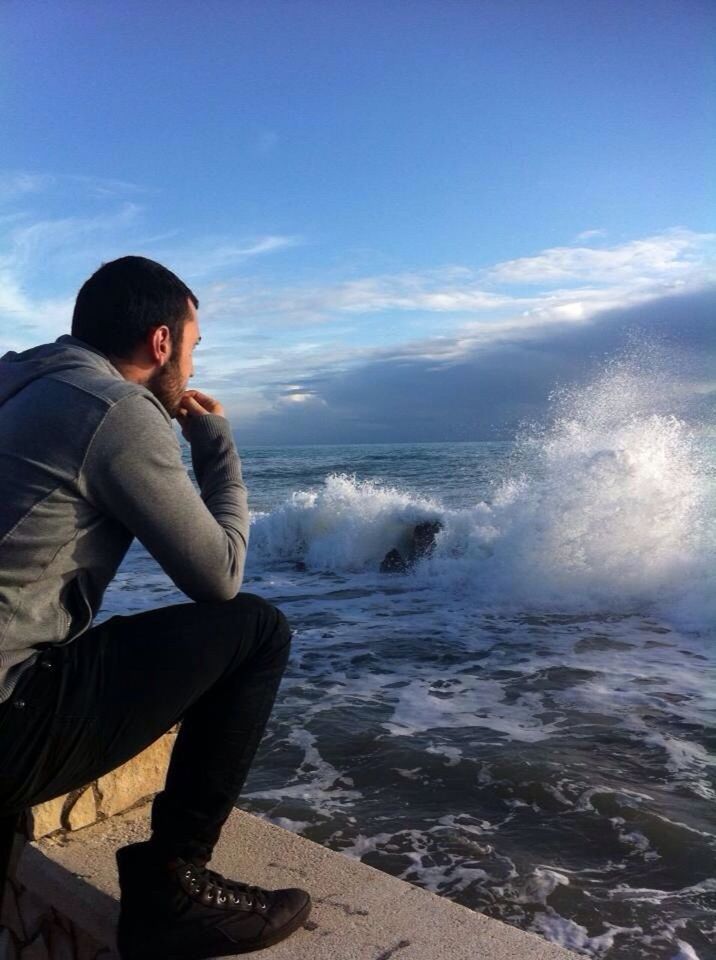 young adult, sea, lifestyles, water, leisure activity, person, young men, casual clothing, sky, beach, vacations, looking at camera, horizon over water, beauty in nature, standing, portrait, scenics