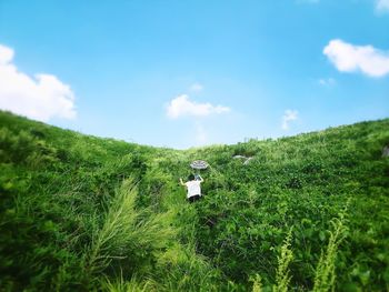 Scenic view of grassy field against cloudy sky