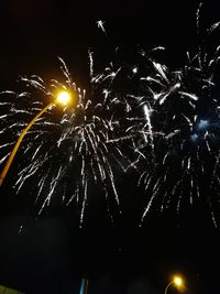 Low angle view of firework display at night