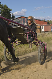 Rear view of man riding horse on field