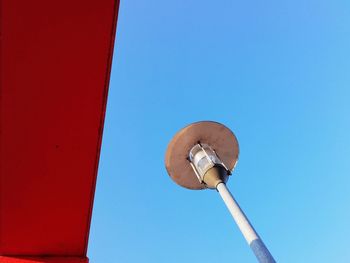 Low angle view of communications tower against clear blue sky