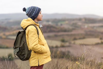 Side view of man looking away while standing on land