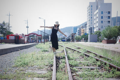 Rear view of man walking on railroad track