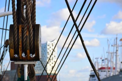 Close-up of rope tied on metal against sky