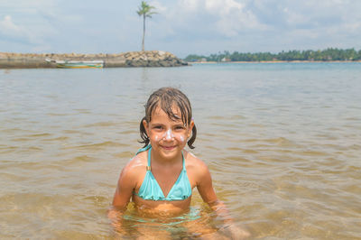 Portrait of young woman swimming in sea