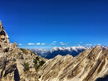 Scenic view of snowcapped mountains against blue sky