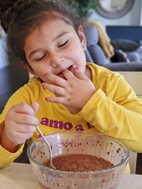 Cute girl eating food at home