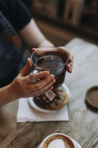 Hand holding coffee cup on table