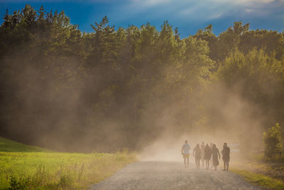 Rear view of people on landscape against sky