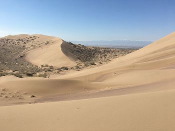 Sand dunes in desert against sky