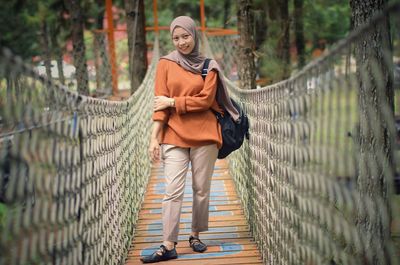 Full length of woman standing on footbridge