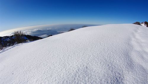 Scenic view of snowcapped mountains against clear blue sky