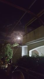 Low angle view of illuminated buildings against sky at night