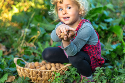 Portrait of cute baby boy standing by plants