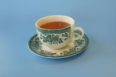 Coffee cup on table against blue background