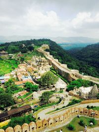 Aerial view of houses on mountain against cloudy sky