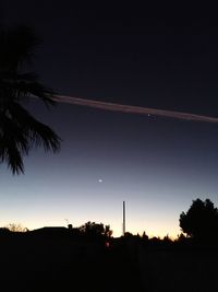 Silhouette palm trees against sky at sunset