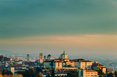 View of cityscape against cloudy sky