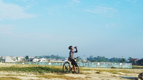 Man riding motorcycle on land against sky