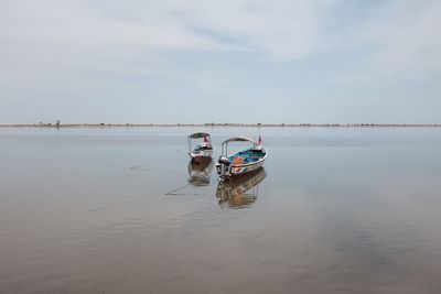 Boat moored on sea against sky