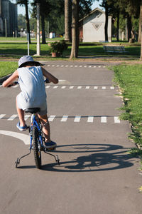 Little boy riding bike on sidewalk 