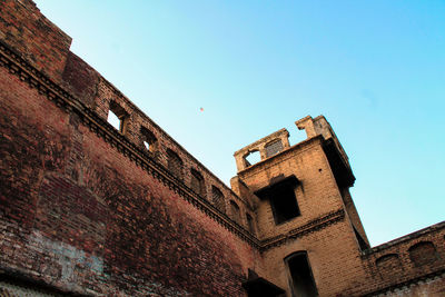 Low angle view of old building against blue sky