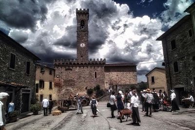 People in town square against cloudy sky