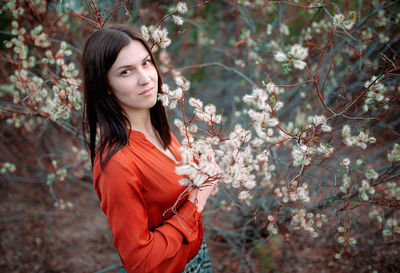 Portrait of beautiful woman with red flower