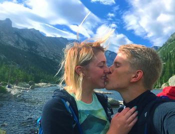 Woman standing on mountain against sky