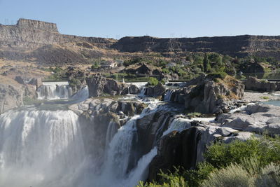 Scenic view of waterfall against sky