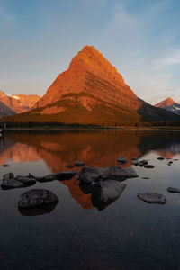 Scenic view of lake by mountains against sky