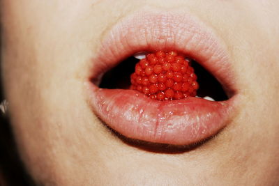 Close-up of woman eating raspberry