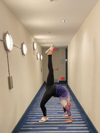 Full length of young woman exercising in gym