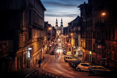 Road amidst buildings in city at night