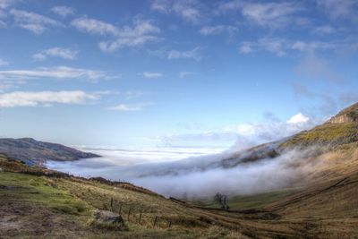 Scenic view of mountains against cloudy sky