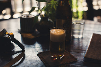 Close-up of beer glass by camera on table