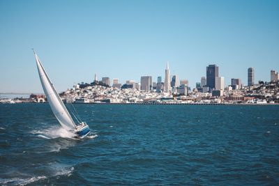 Ship sailing in sea against clear blue sky