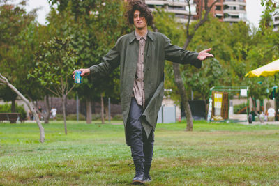 Happy boy standing by plants against trees