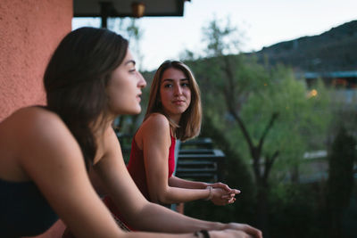 Lesbian couple leaning in balcony