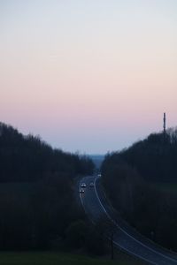 Road amidst trees against clear sky