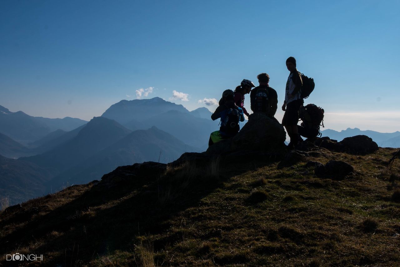 mountain, silhouette, tranquil scene, scenics, tourism, tranquility, travel destinations, tourist, mountain range, vacations, travel, nature, adventure, beauty in nature, togetherness, mountain peak, non-urban scene, cliff, exploration, enjoyment, rock formation, sky, person, carefree