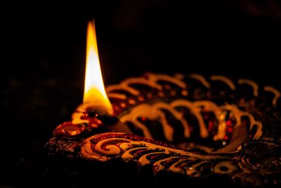 Close-up of lit candle in the dark
