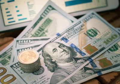 Close-up of coins and us paper currency on brick